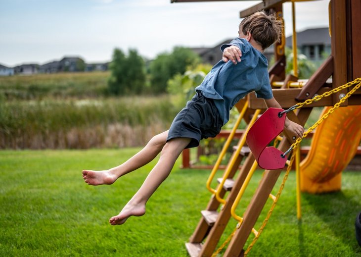 Dreng der hopper af en gynge